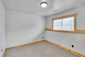 Carpeted spare room with a textured ceiling