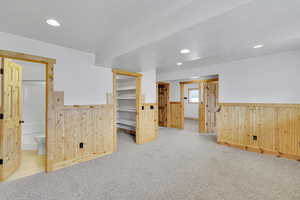 Carpeted empty room featuring wood walls and a textured ceiling