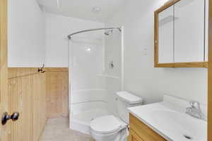 Bathroom featuring vanity, tile patterned floors, toilet, and walk in shower