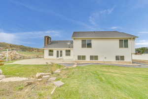 Rear view of house featuring a patio and a yard