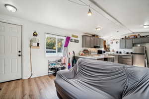 Living room featuring vaulted ceiling with beams and light hardwood / wood-style flooring