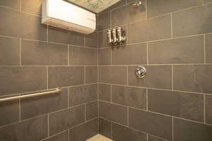 Bathroom with a tile shower and a wall mounted AC