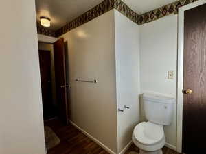 Bathroom featuring hardwood / wood-style flooring, toilet, and a textured ceiling