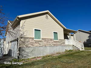 View of home's exterior featuring a garage and a yard