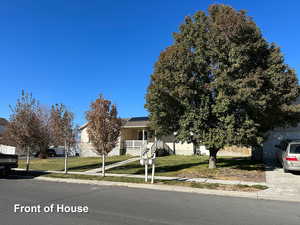 Obstructed view of property featuring a porch and a front yard