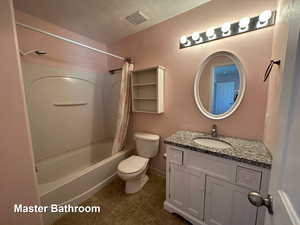 Full bathroom with tile patterned floors, toilet, a textured ceiling, vanity, and shower / bathtub combination with curtain