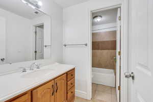 Full bathroom featuring vanity, tiled shower / bath combo, toilet, and tile patterned floors