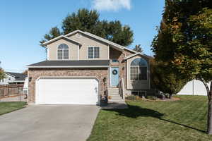 View of front of house featuring a front lawn and a garage