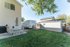 View of yard featuring a storage shed and a patio area