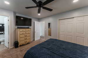 Bedroom featuring connected bathroom, ceiling fan, a closet, and carpet