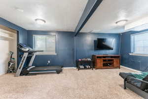 Workout area featuring a textured ceiling and carpet floors