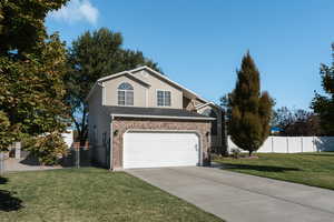 View of front property featuring a front yard and a garage