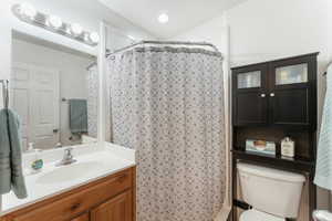 Bathroom featuring vanity, toilet, and a shower with curtain