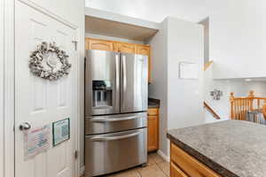 Kitchen with stainless steel fridge with ice dispenser and light tile patterned floors