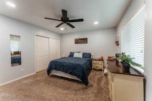 Bedroom featuring carpet flooring, a closet, and ceiling fan