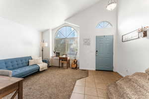 Carpeted entrance foyer with vaulted ceiling