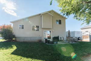 Rear view of property with a patio area and a lawn