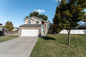 View of property with a garage and a front lawn