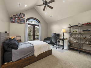 Carpeted bedroom featuring access to outside, high vaulted ceiling, and ceiling fan