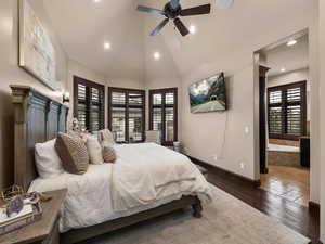 Bedroom with connected bathroom, dark wood-type flooring, vaulted ceiling, and ceiling fan