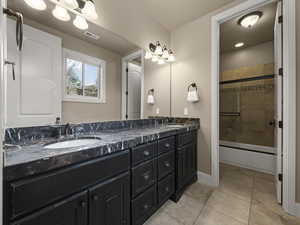 Bathroom with vanity, enclosed tub / shower combo, and tile patterned floors