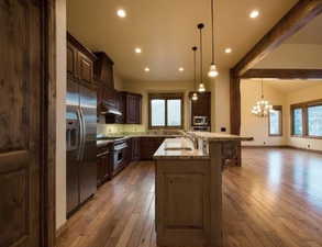 Kitchen featuring stainless steel appliances, hanging light fixtures, sink, and dark hardwood / wood-style flooring