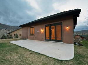 Rear view of property with a patio, a mountain view, and a yard