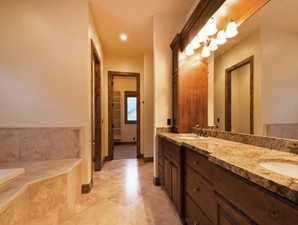 Bathroom with vanity and tiled tub