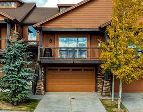 View of front facade featuring a balcony and a garage