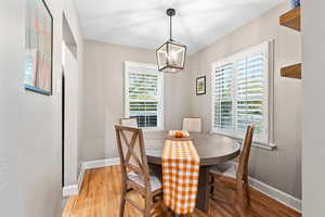 Dining room with light hardwood / wood-style floors and a chandelier