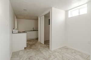 Corridor featuring sink and a textured ceiling