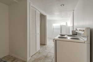 Kitchen featuring white appliances and a textured ceiling