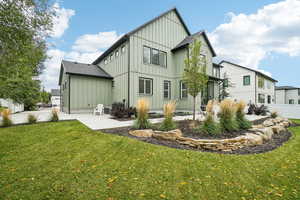 Rear view of house with a lawn and a garage