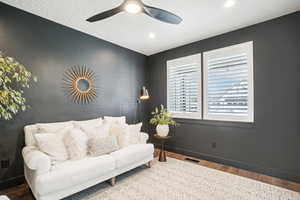 Living room with wood-type flooring and ceiling fan