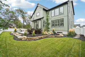 Rear view of house featuring a yard