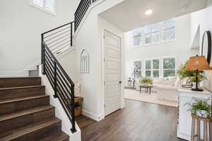 Staircase featuring a towering ceiling and hardwood / wood-style floors