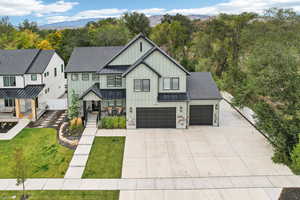 Modern inspired farmhouse featuring a front yard, a garage, and a mountain view