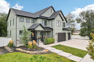 Modern farmhouse style home with a front yard, covered porch, and a garage