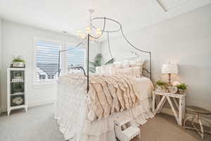 Bedroom featuring carpet, a textured ceiling, and an inviting chandelier