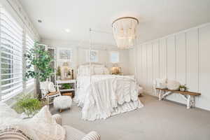 Carpeted bedroom featuring a chandelier