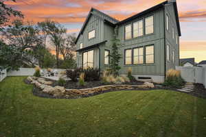 Back house at dusk with a lawn