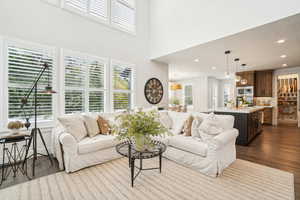 Living room featuring hardwood / wood-style flooring and a towering ceiling