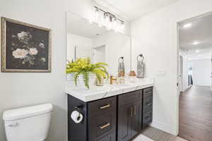 Bathroom with vanity, wood-type flooring, and toilet