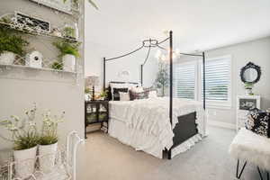 Bedroom with a textured ceiling, a chandelier, and carpet flooring