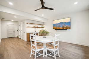 Dining room with sink, light hardwood / wood-style flooring, and ceiling fan