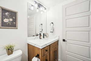 Bathroom with vanity, a textured ceiling, and toilet