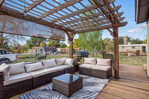 Wooden terrace featuring a yard, grilling area, a pergola, an outdoor living space, and a shed