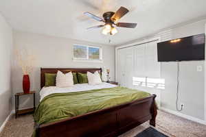 Bedroom with a closet, carpet floors, a textured ceiling, and ceiling fan