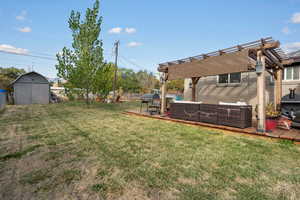 View of yard featuring a shed, a patio area, a pergola, and an outdoor hangout area