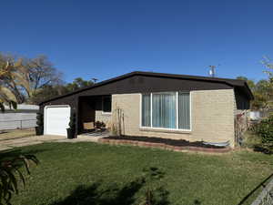 View of side of property featuring a yard and a garage